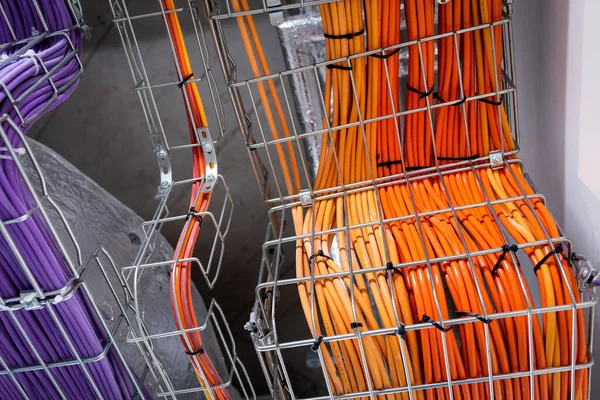 Electrical conduits system and metal pipeline installed on building ceiling. orange and purple wires