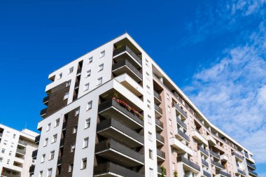 Değişik apartman binaları, balkonları ve parlak mavi gökyüzü altında kentsel tasarımı olan modern yerleşim yerleri..