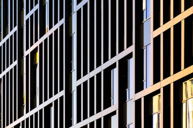 Modern ofis, şebeke benzeri karanlık çerçeve ve yansıtıcı pencerelerle derinlik, düzen ve mimari ritim yaratıyor..