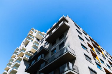 Değişik apartman binaları, balkonları ve parlak mavi gökyüzü altında kentsel tasarımı olan modern yerleşim yerleri..