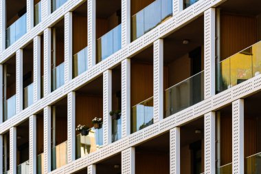 Camdan balkonları, delinmiş panelleri ve tekrarlayan geometrik ritmi olan yerleşim binaları modern şehir tasarımı yaratıyor..