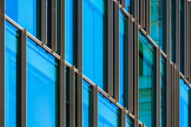 Modern ofis, şebeke benzeri karanlık çerçeve ve yansıtıcı pencerelerle derinlik, düzen ve mimari ritim yaratıyor..