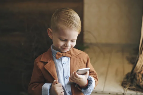 Verrast jongen met slimme horloge op terras zitten en het gebruik van mobiele telefoon — Stockfoto