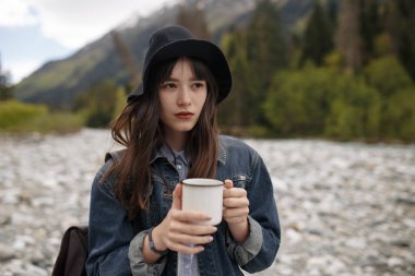 sıcak fincan kahve ya da çay buautiful dağ arka plan ile sabah güneş ışığı altında tutan eller.