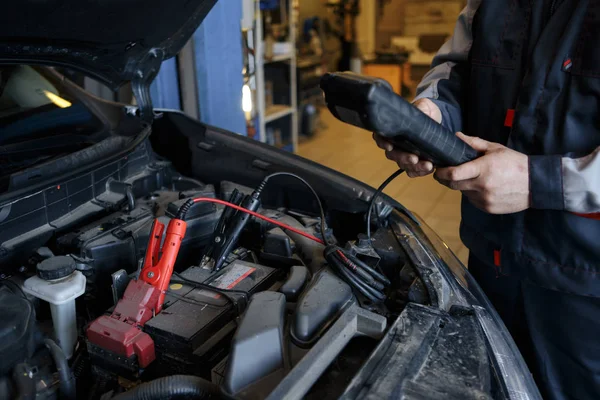 Cargador de batería y coche en taller de reparación de automóviles . —  Fotos de Stock