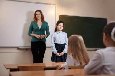 liseli kız gülümseyerek blackboard, görev gerçekleştirir. Eğitim.