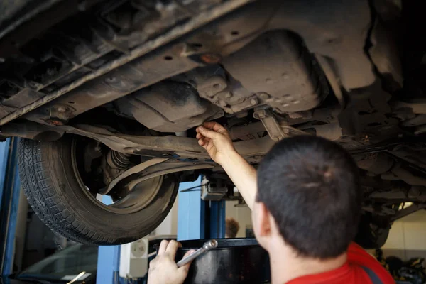 Profecional carro mecânico mudando óleo do motor no motor automóvel na estação de serviço de reparação de manutenção em uma oficina de carro . — Fotografia de Stock