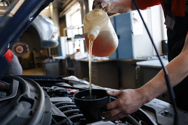Fresh oil being poured during an oil change to a car — Stock Photo, Image