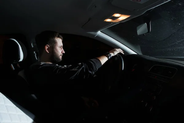 Hombre de negocios conduciendo un coche por la noche — Foto de Stock