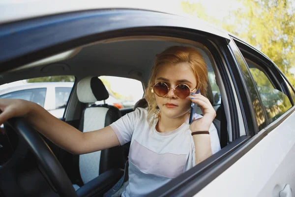 Молода жінка сидить у машині і кличе — стокове фото