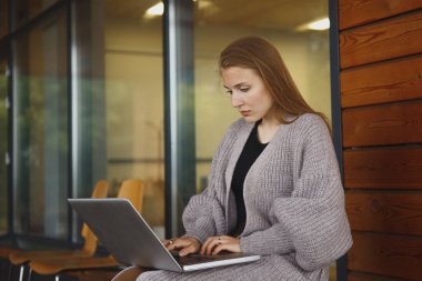 Üzgün bir kız portresi yerde otururken atlet holding laptop içinde giyinmiş