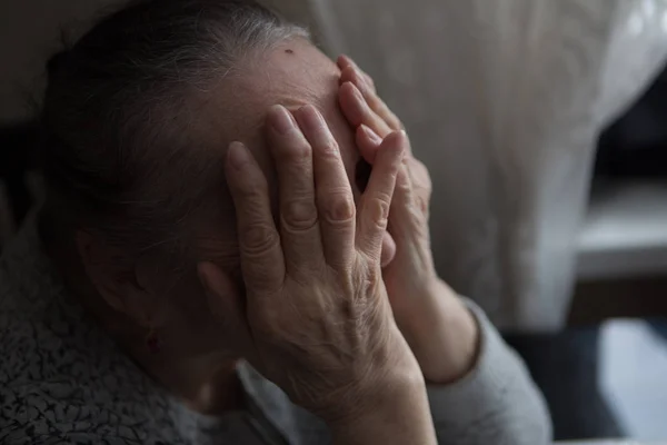 Гранж-портрет пожилой женщины, страдающей от головной боли с отчаянным выражением лица — стоковое фото