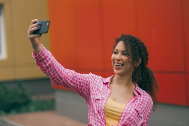 Şehirde yürüyüş, kahve içme, kendini güneşli bir günde fotoğraf çekme Cheert Selfie zaman mutlu bayanın bir bahar tatili