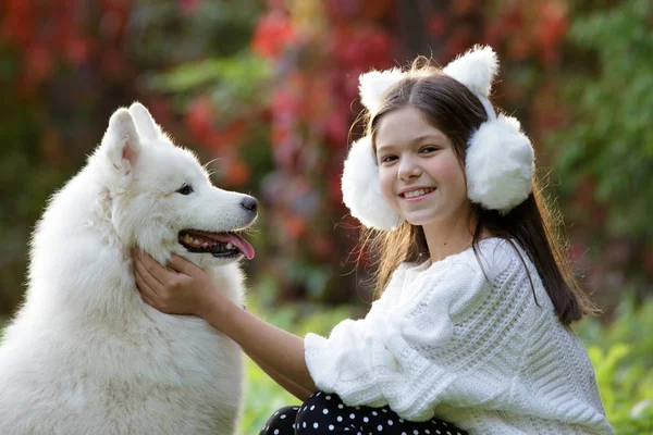 Menina abraçando seu cão em um parque — Fotografia de Stock