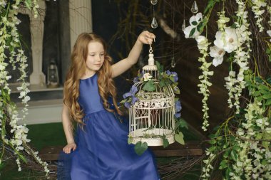 Dekoratif Kuş kafesi çiçek tam tutan mutlu küçük kız. Provence stili iç stüdyo vurdu