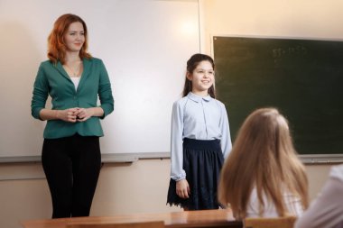 Yaşlı öğretmen öğrenci matematik dersine soran kara tahta yakınındaki gülümseyen