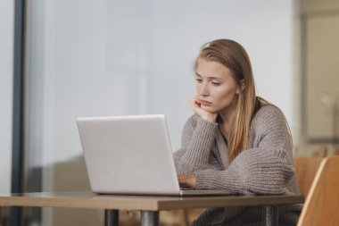 Bir tablet bakarak bir kafede üzgün kız
