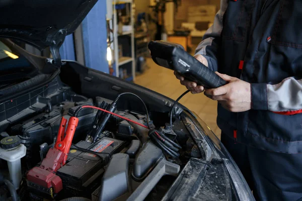 Auto mécanicien vérifier la tension de la batterie de voiture — Photo