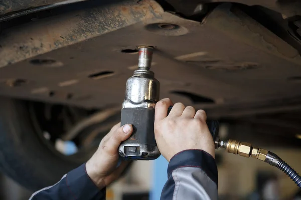 Profecional car mechanic changing motor oil in automobile engine at maintenance repair service station in a car workshop.