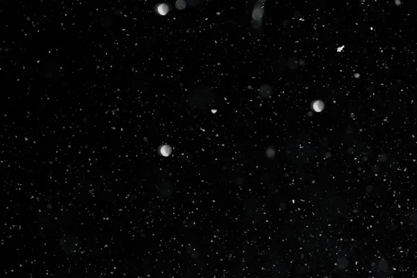 Neve em um fundo preto textura sobreposição bokeh destaques — Fotografia de Stock