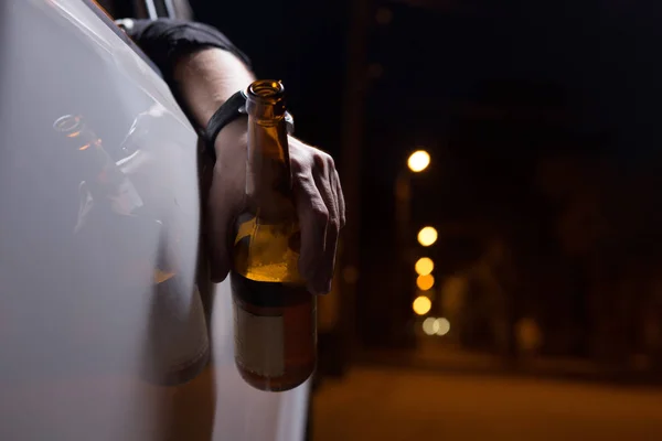 Drunk young man driving a car with a bottle of beer. Dont drink and drive concept. Driving under the influence. DUI, Driving while intoxicated. DWI — Stock Photo, Image