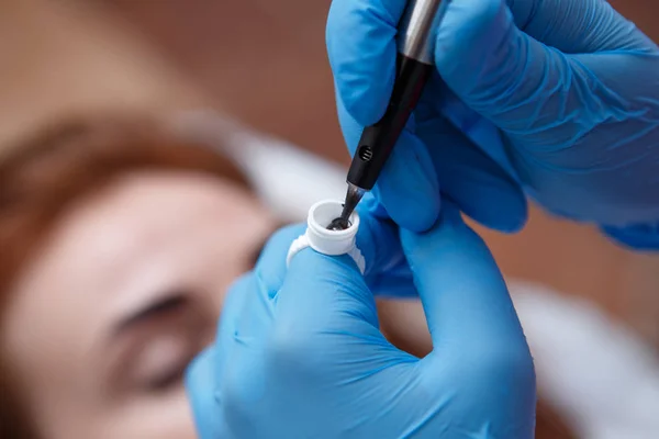 Kosmetolog stosujący stały makijaż na oczach - tatuaż brwi — Zdjęcie stockowe