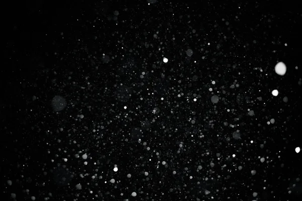 Textura bokeh sníh na černém pozadí — Stock fotografie
