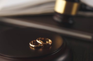 Nikah yüzüklerinin yakınındaki tahta tokmak mahkeme salonundaki masada.