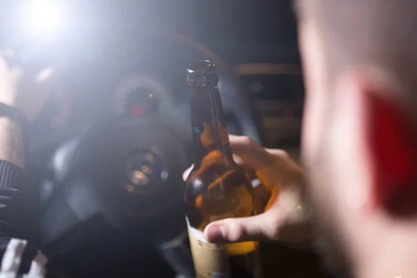 Berusad ung man köra en bil med en flaska öl. Dont drink och driva konceptet. Bilkörning under påverkan. DUI, rattfylleri. DWI — Stockfoto