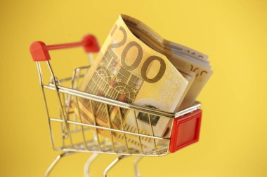 Alışveriş sepeti Tay madeni paralarla dolu sarı izole.