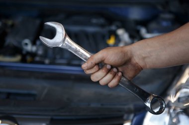 İngiliz anahtarını tutan araba teknisyeni