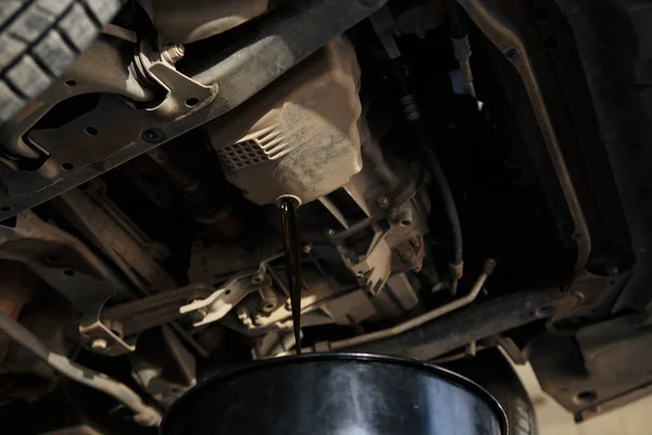 Óleo de despejo mecânico no carro na garagem de reparação — Fotografia de Stock