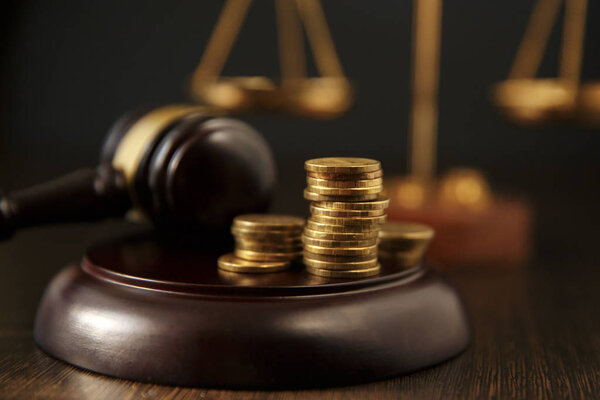 Крупный план человека ручной укладки монет перед молотком на сером фоне
