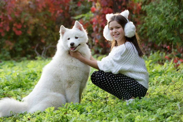 Szczęśliwe dziecko z psem w zielone pole — Zdjęcie stockowe