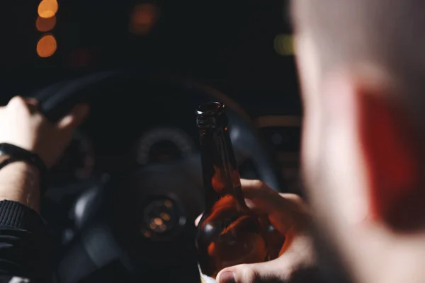 Un joven borracho conduce un auto con una botella de cerveza. Esta es una foto de campaña de "Dont Drink for Drive ." — Foto de Stock