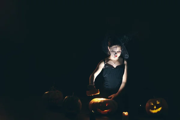 Bonito e bonito menina com longos cachos posando para halloween vestindo um enorme chapéu preto e laranja — Fotografia de Stock