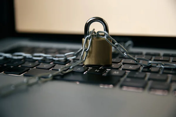 Cyber safety concept, locked chain on laptop computer keyboard