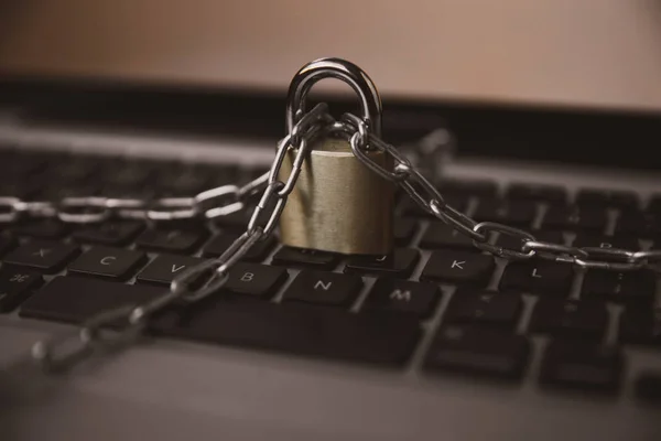 Cyber safety concept, locked chain on laptop computer keyboard