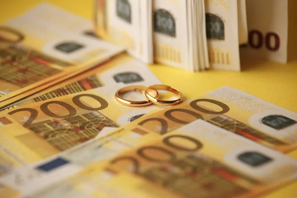 Golden wedding rings on euro banknotes background. Marriage of convenience — Stock Photo, Image