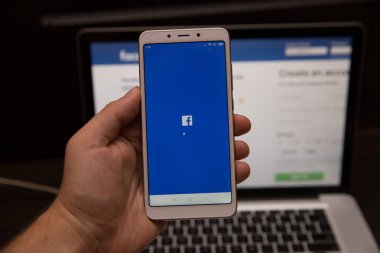 Tula, Rusya - 31 Ekim 2018: Facebook sosyal medya app iş yerinde iş kişi elinde akıllı cihazlar ekranda hareket eden app kütük-içinde kayıt kayıt sayfasına logo