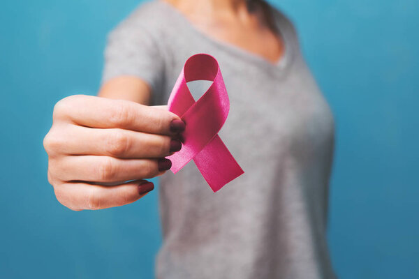 womaen hand holding pink ribbon breast cancer awareness. concept healthcare and