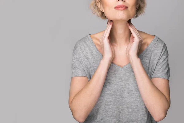 Female checking thyroid gland by herself. Close up of woman in white t- shirt touching neck with red spot. Thyroid disorder includes goiter, hyperthyroid, hypothyroid, tumor or cancer. Health care. — Stock Photo, Image