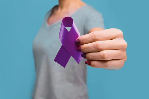 Mujer mayor sosteniendo la conciencia de cinta púrpura w espacio de copia. El símbolo se utiliza para crear conciencia sobre la enfermedad de Alzheimer, el abuso de ancianos, la epilepsia, el cáncer de páncreas, el cáncer de tiroides y el lupus. . — Foto de Stock