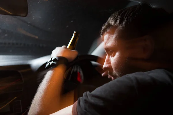 Drunk driver. Man drinking beer while driving a car — Stock Photo, Image