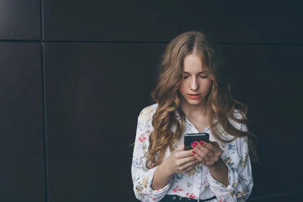 Infelice ragazza adolescente guarda il suo smartphone sperimentando ansia e tristezza . — Foto Stock
