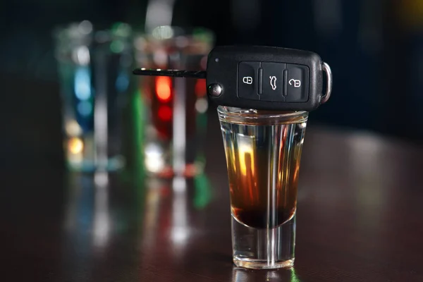 Drinking and driving concept. Car key on a wooden table, pub — Stock Photo, Image