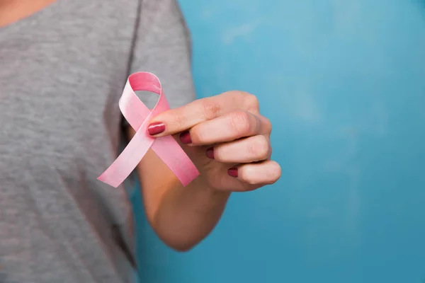 Womaen mano sosteniendo cinta rosa conciencia de cáncer de mama. concepto de asistencia sanitaria y — Foto de Stock