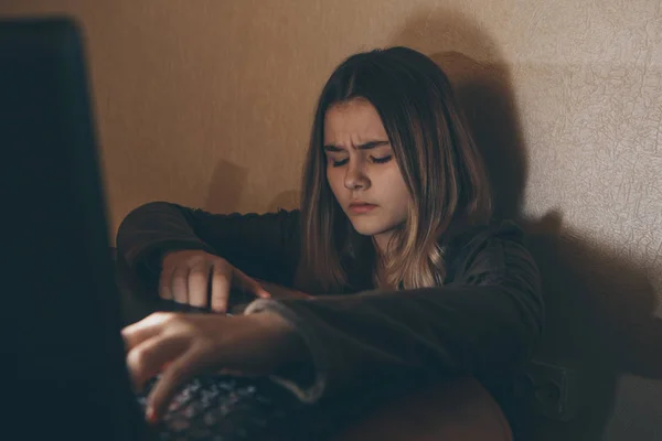 Teenager-Mädchen, die unter Cybermobbing im Internet leiden, haben Angst und sind depressiv. Bild eines verzweifelten Mädchens, das von einer Klassenkameradin im Internet gedemütigt wurde. junges Teenager-Mädchen weint vor dem Laptop — Stockfoto