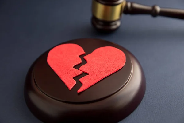 Los anillos de boda en la figura del corazón roto del árbol, el martillo del juez sobre el fondo de madera. Divorcio — Foto de Stock