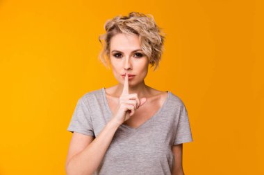 Sessizlik. Sessizlik ya da gizlilik parmak üzerinde soran kadın sus el jest sarı arka plan duvar dudakları. Güzel kız dudaklarından, sus işareti simgesi parmak yerleştirerek. Negatif duygu yüz ifadesi